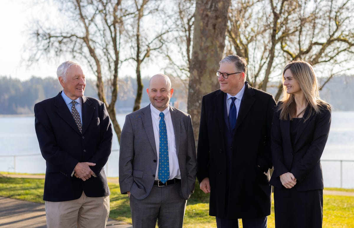 Bill H. Broughton, David P. Horton, David A. Weibel and Christy Palmer on the waterfront with a tree line behind them