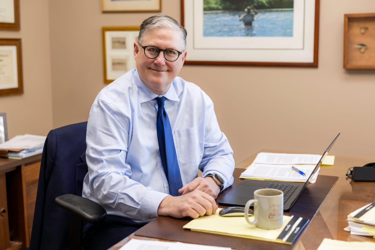 Partner David A. Weibel at his desk with a laptop and legal pad