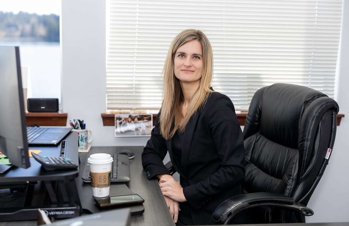 Christy Palmer, Partner at Kitsap Law Group, at her desk by a window with water outside