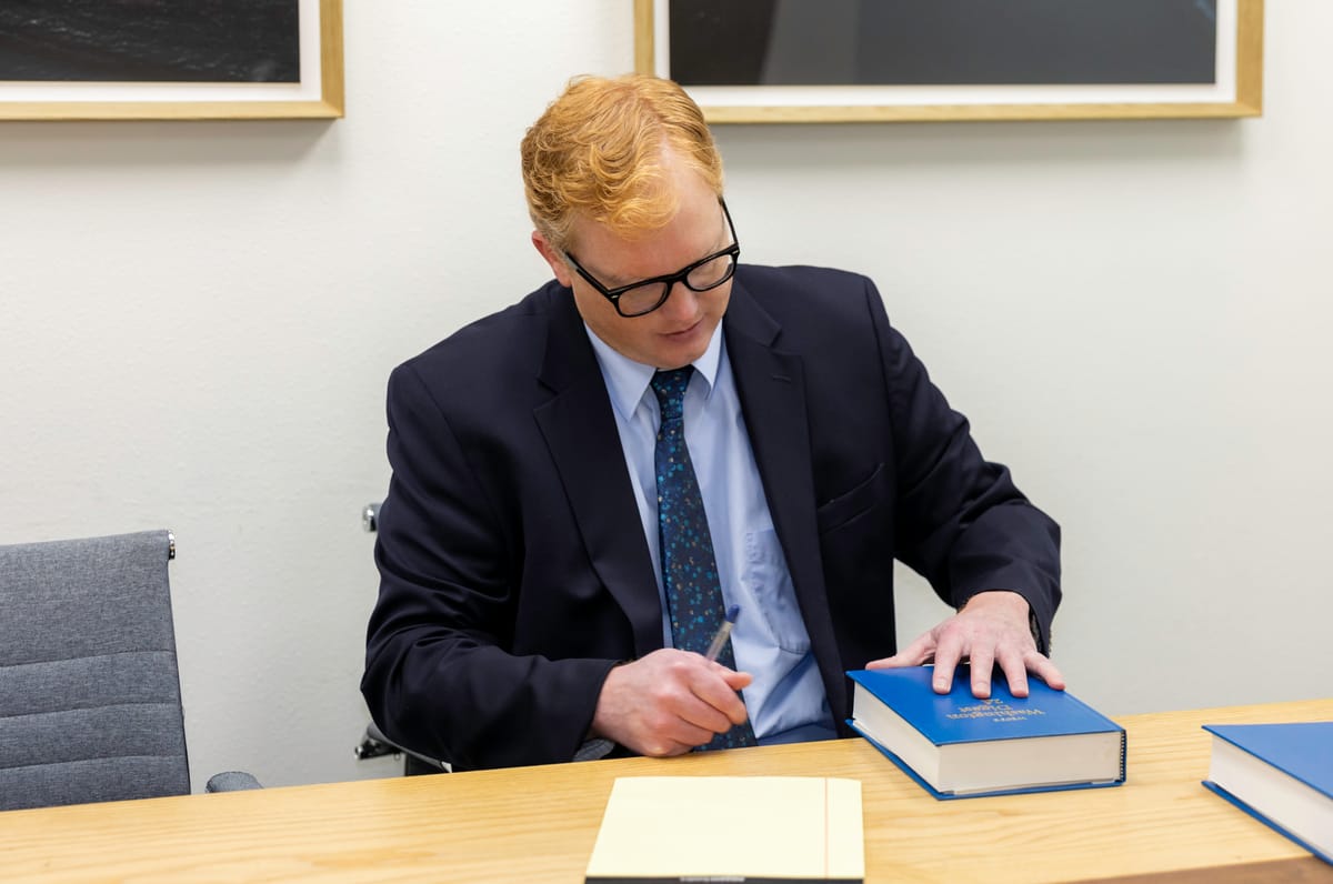 John Brennan, Associate at Kitsap Law Group, in the conference room with law books