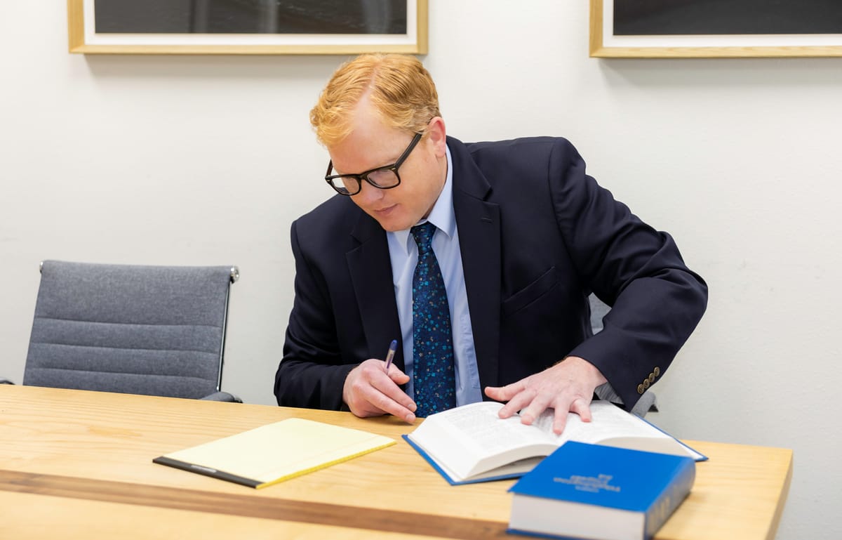 Attorney John Brennan reviewing a law book in the conference room